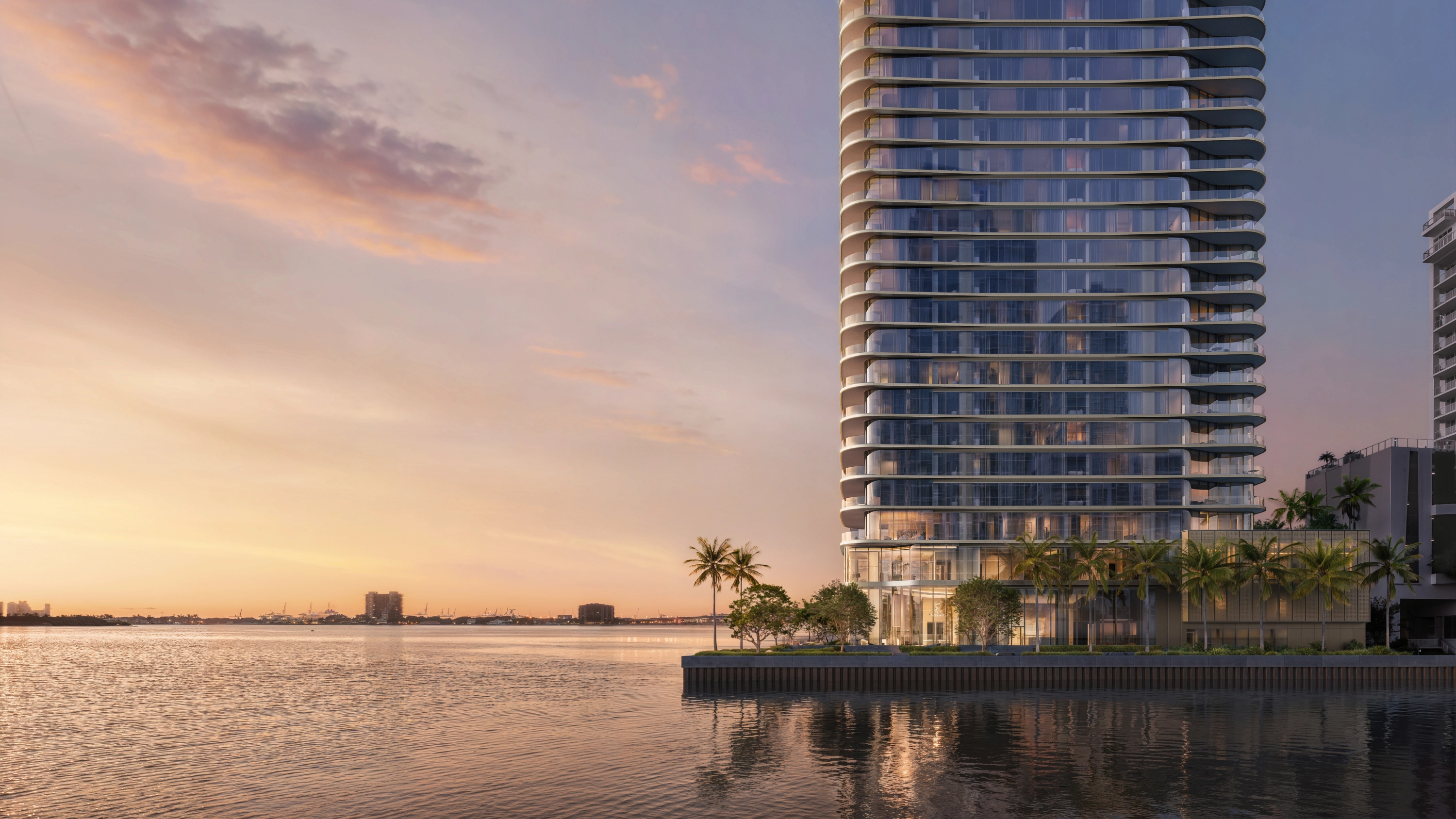 Edgewater Miami condos: LILLI residential tower at dusk beside water and palm trees.
