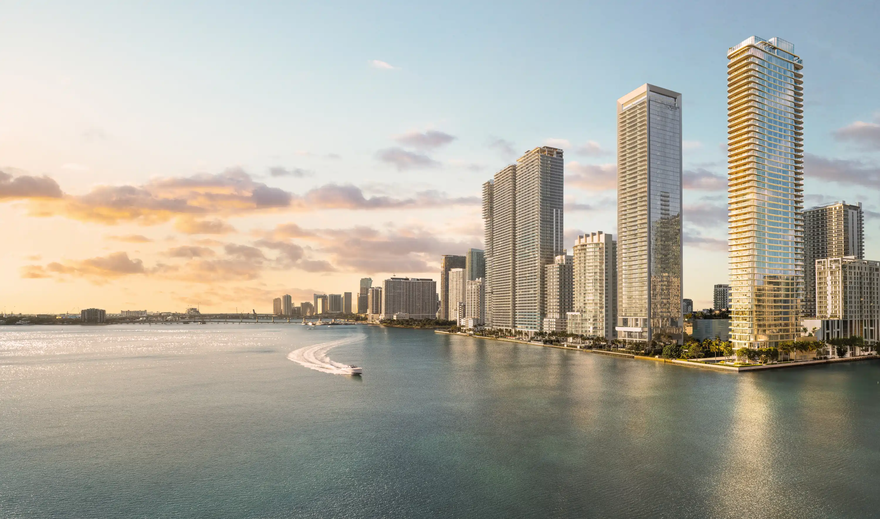 A boat speeds across Biscayne Bay past modern luxury Edgewater Miami condos and waterfront skyscrapers at sunset.